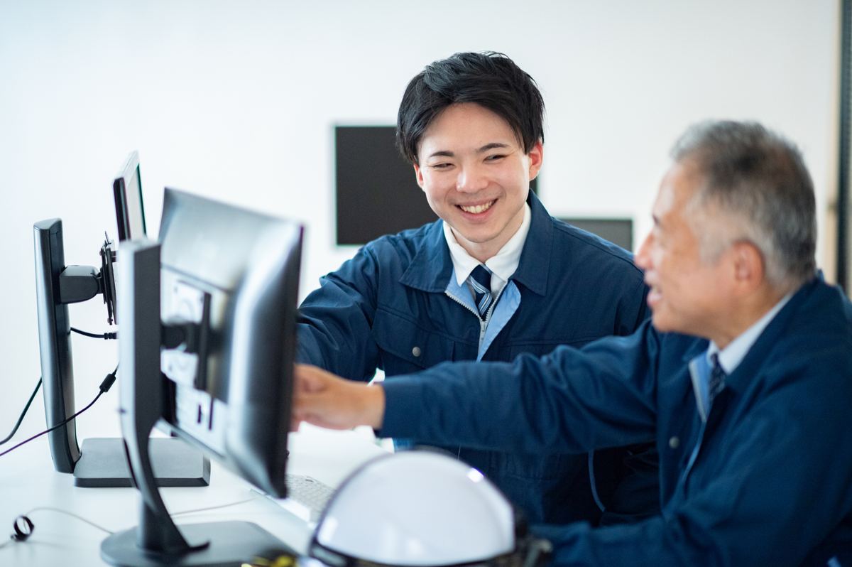 モニターを前に話す製造会社の社員
