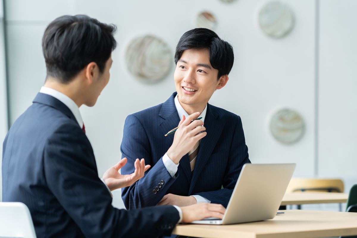 ノートPCを前に打ち合わせする営業担当